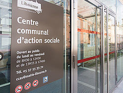 Vue de l'entrée du CCAS de Libourne avec plaque officielle et horaires d'ouverture